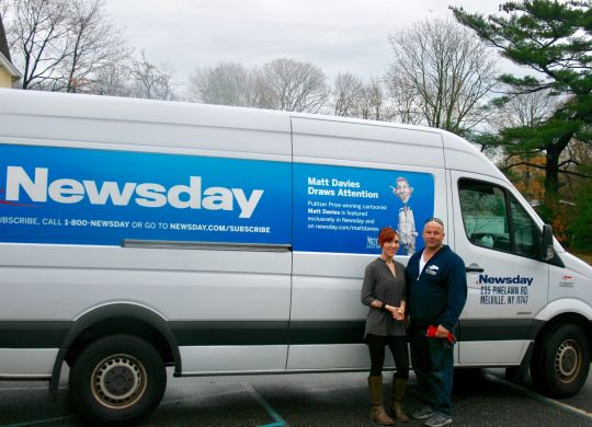 Alanna Barrera, CAC staff, and Charlie Monell, Newsday, pose in front of the Newsday van filled with Brain Bender books.