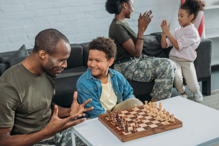 Participants in a foster care program play chess together.