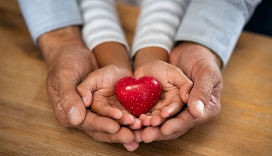 adult and child hands holding heart