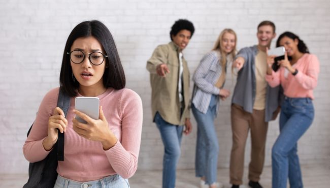 girl on cell phone being cyber bullied