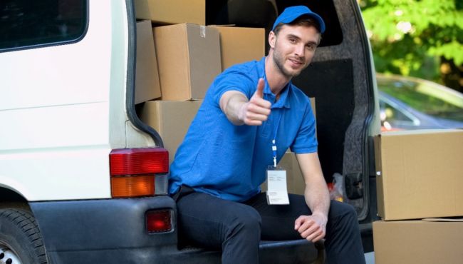 man sitting in a uniform at the back of a work van